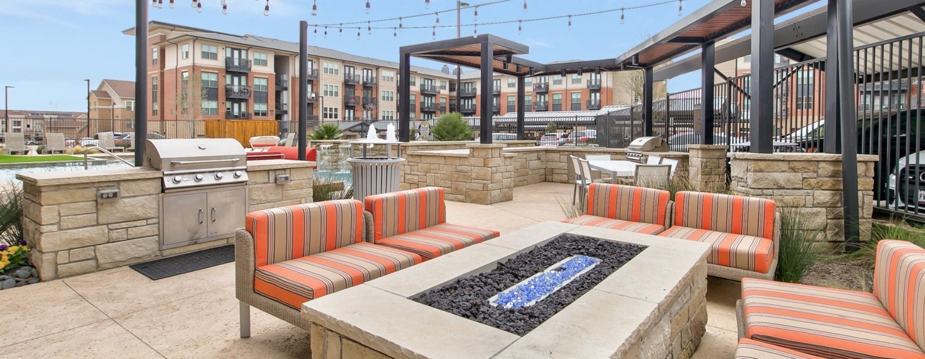 a patio with a grill and couches